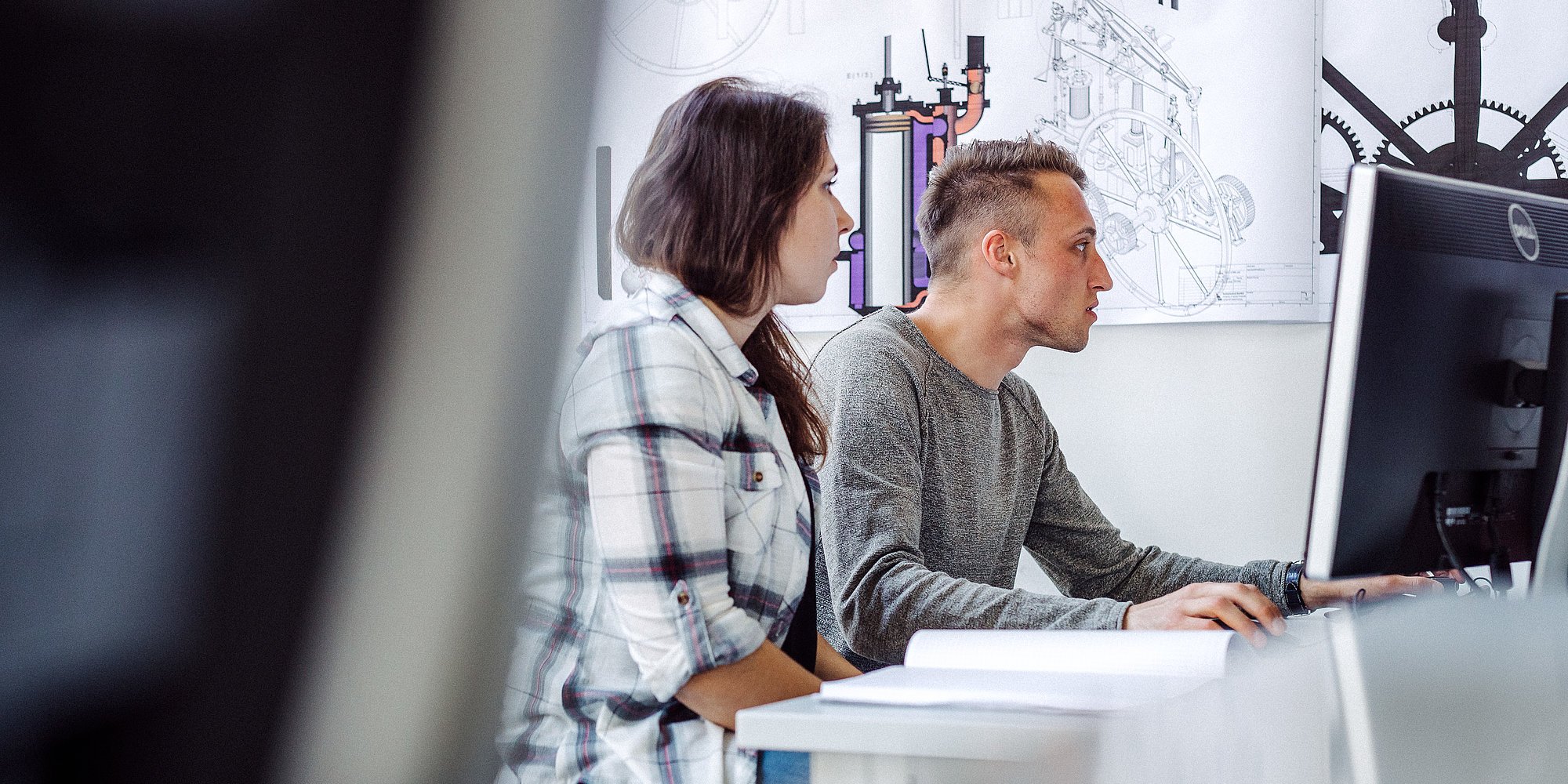 Zwei Personen arbeiten gemeinsam an einem Computer